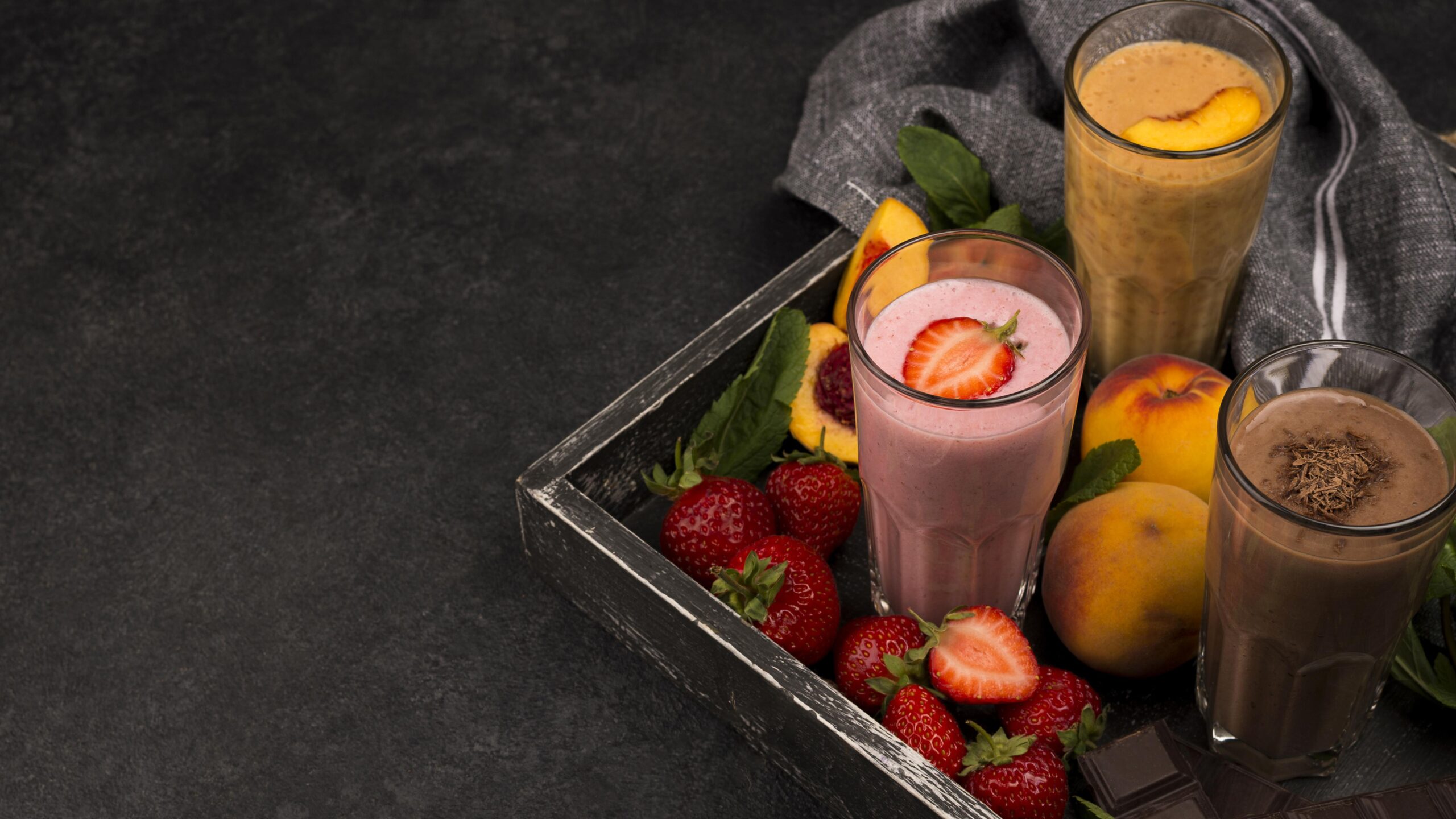 high-angle-milkshake-glasses-tray-with-chocolate-fruits