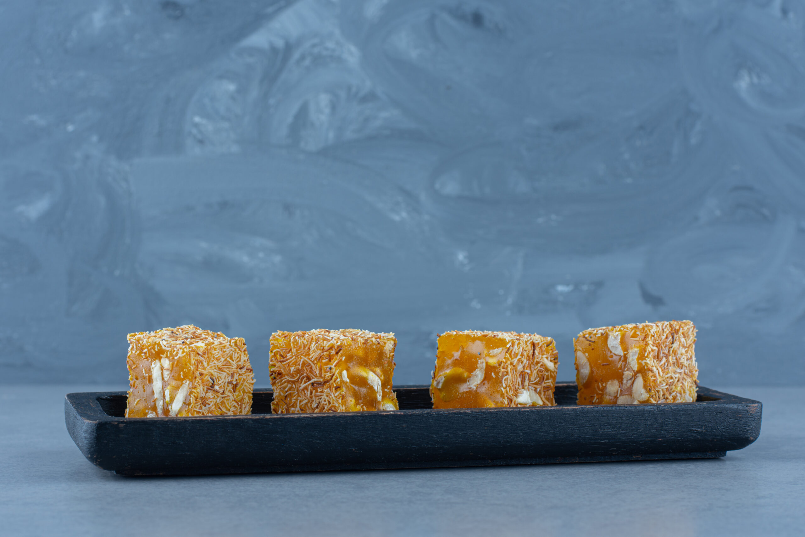 Tasty Turkish delight flavors on a wooden board, on the tea towel, on marble background